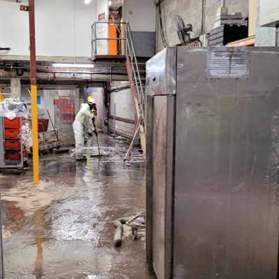 Worker sweeping the floors after flood at Coles Toombul