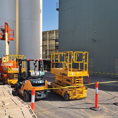 Elevated platform and scissor lift packed up and with safety tape securing the area