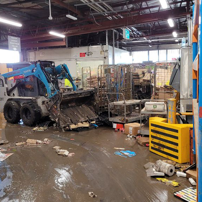 Photo of bobcat parked up while in the process of moving stock from flood damage works at Coles Toombul